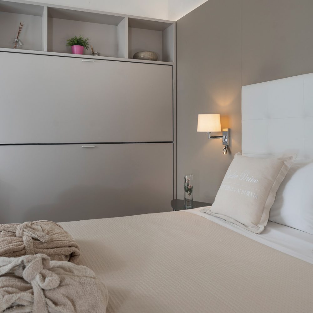 Camera da letto moderna e luminosa con letto matrimoniale, decorazioni eleganti e illuminazione soffusa.