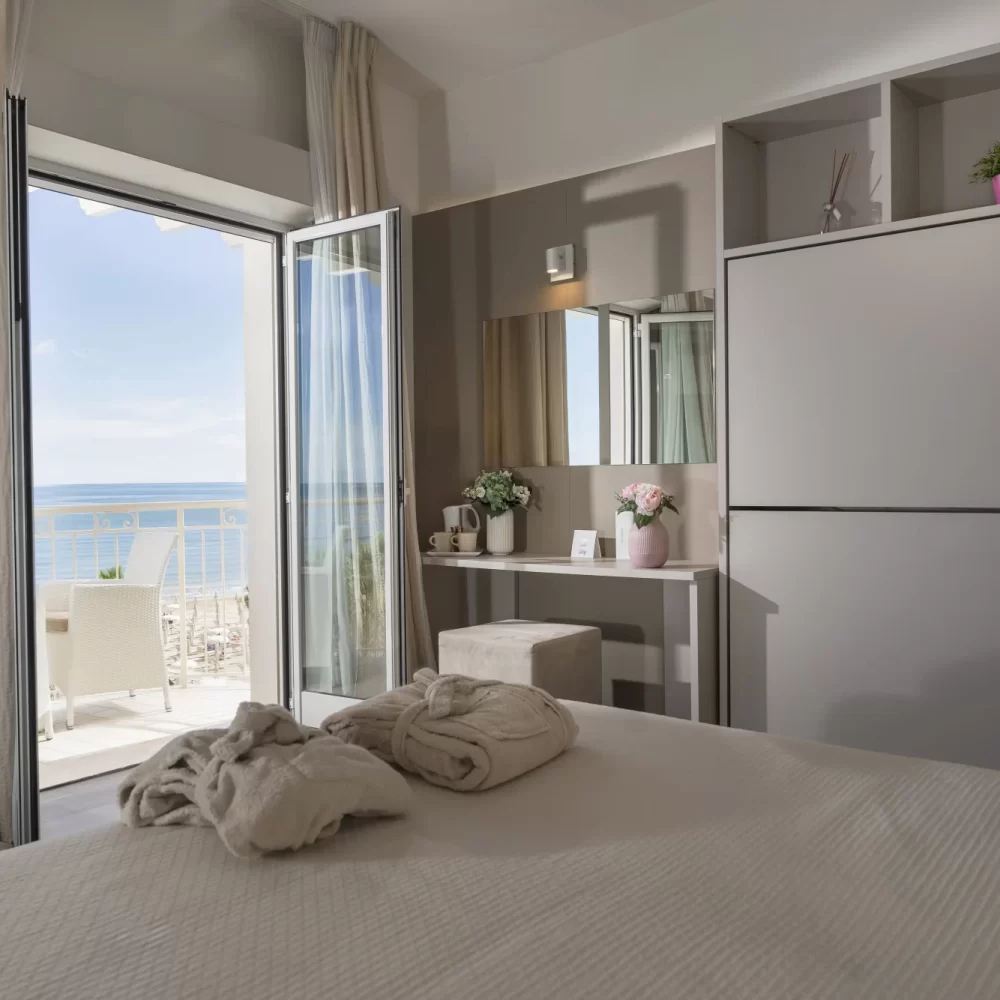 Helles Schlafzimmer mit Balkon und Meerblick.