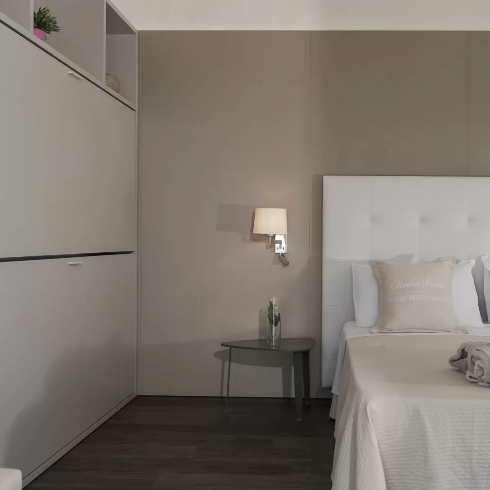 Ein stilvoll eingerichtetes Schlafzimmer mit einem modernen Doppelbett und dezenter Dekoration.