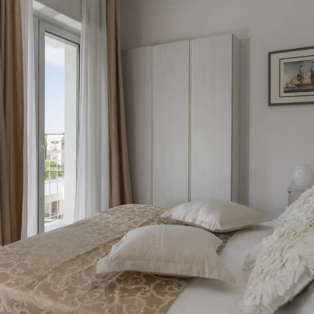 Helles Schlafzimmer mit einem gemütlichen Doppelbett und Wanddekoration.