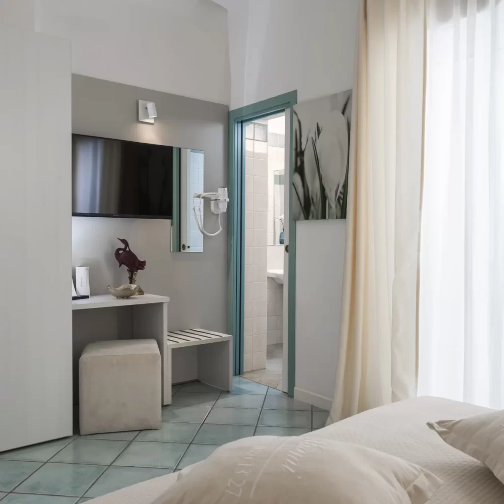 Camera d'albergo luminosa e moderna con vista sul bagno.