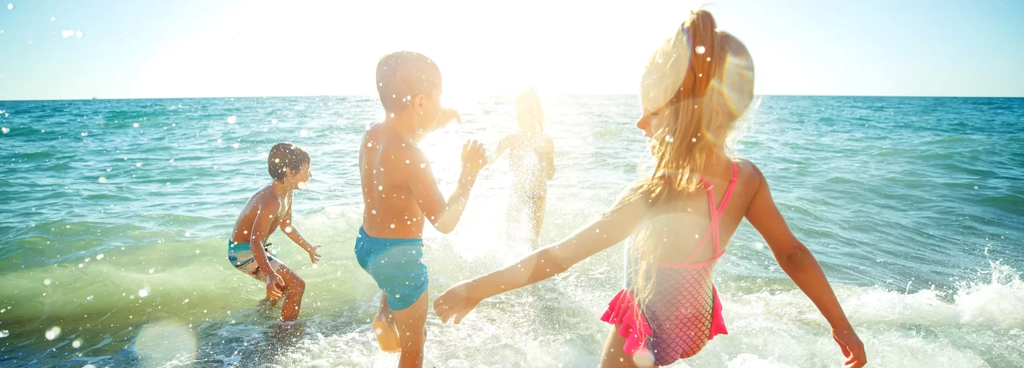 Bambini che giocano e si divertono nell'acqua al sole.