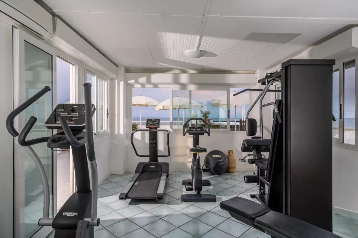 Palestra moderna con vista mare attraverso ampie finestre.