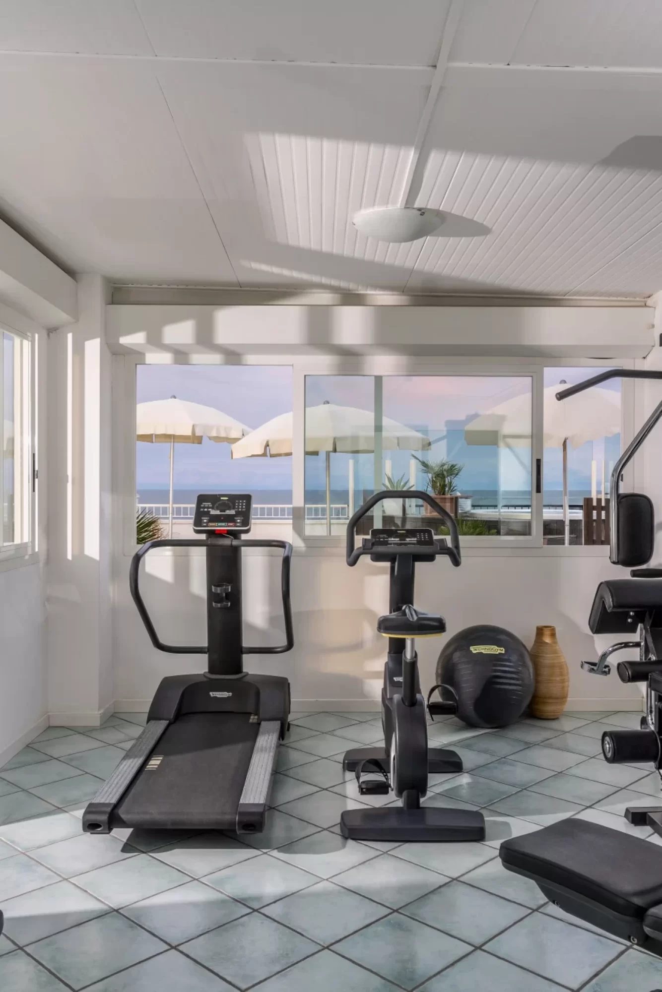 Palestra moderna con vista mare attraverso ampie finestre.