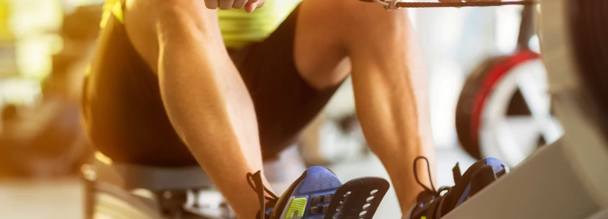 Persona che utilizza una macchina vogatrice in palestra per allenarsi.