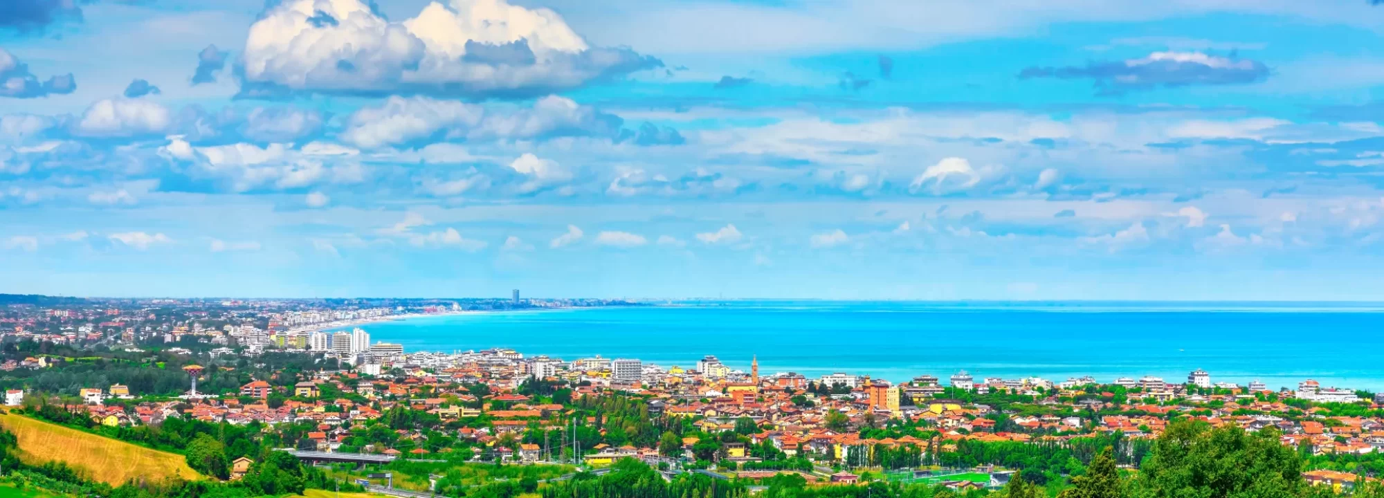 Vista panoramica della costa e della città con il mare e il cielo blu sullo sfondo.
