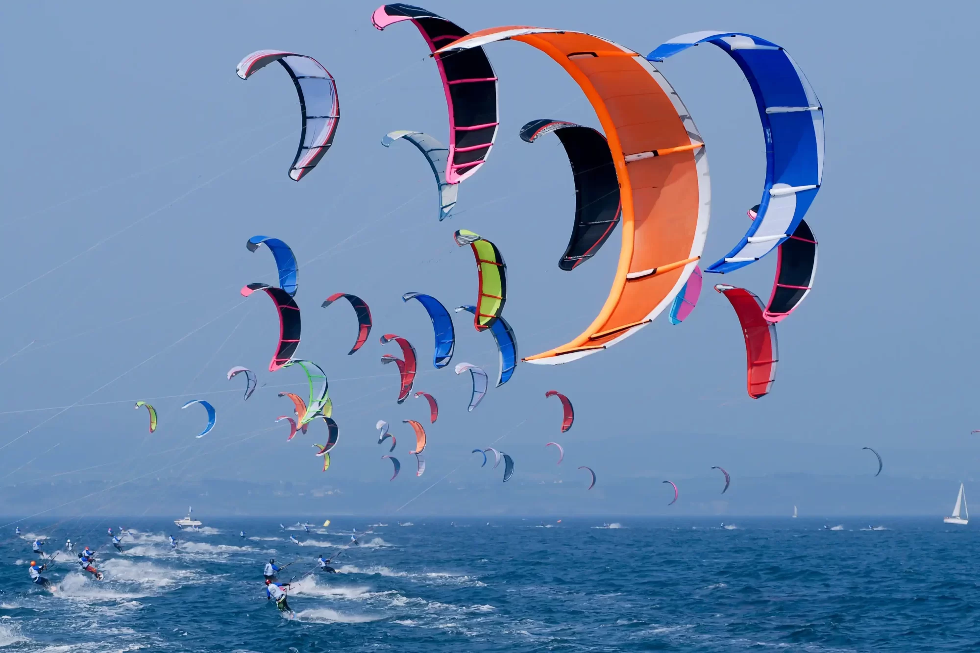 Colorate vele da kitesurfing solcano il cielo sopra l'oceano.