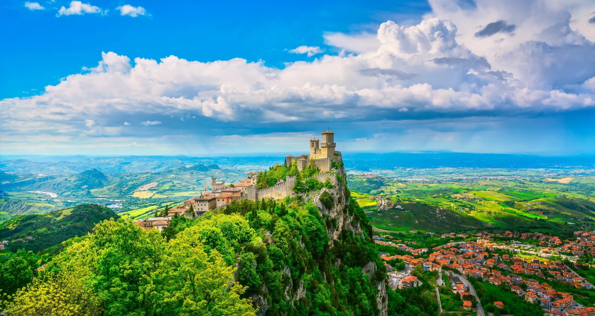 Vista panoramica di San Marino con il castello e paesaggio collinare.