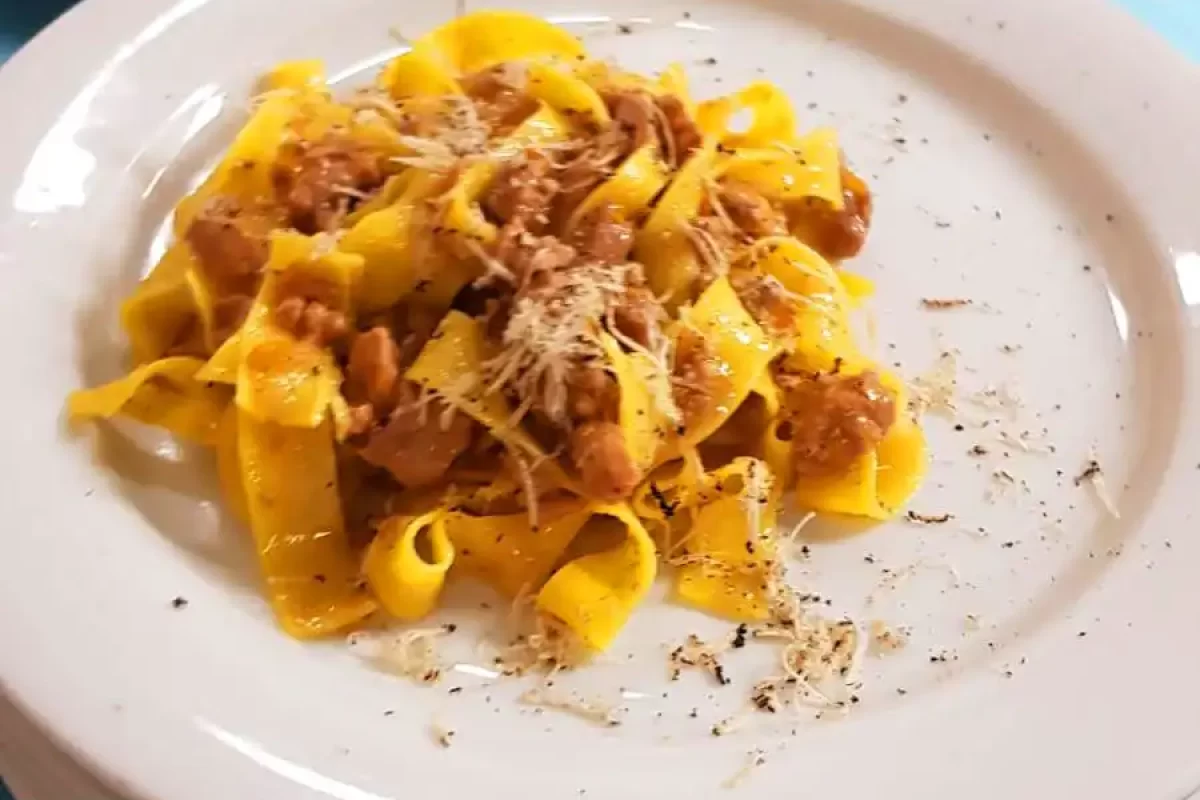 Un piatto di tagliatelle al ragù servito su un piatto bianco.