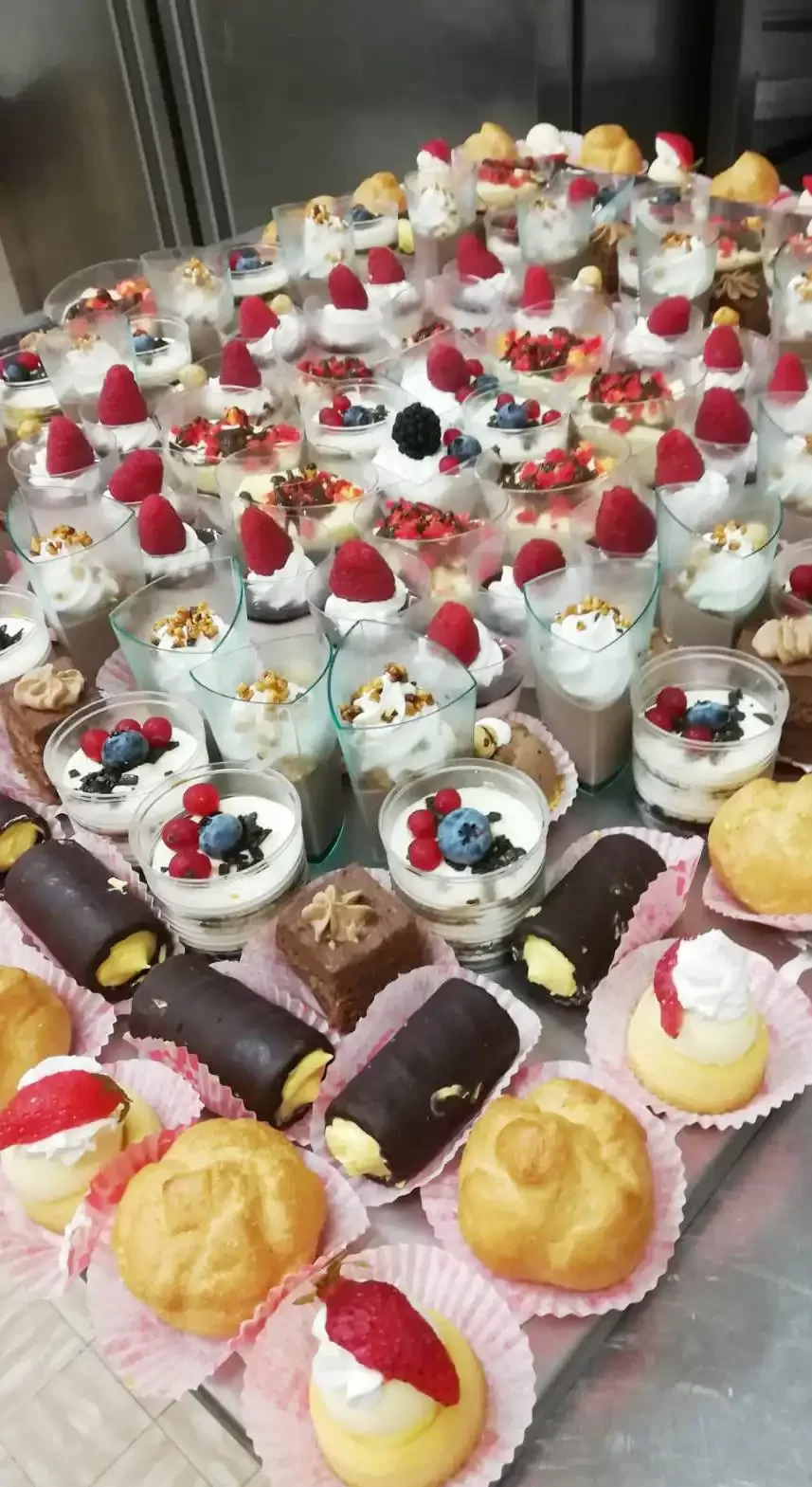 Un assortimento di dolci al cucchiaio e pasticcini decorati con frutta e crema.