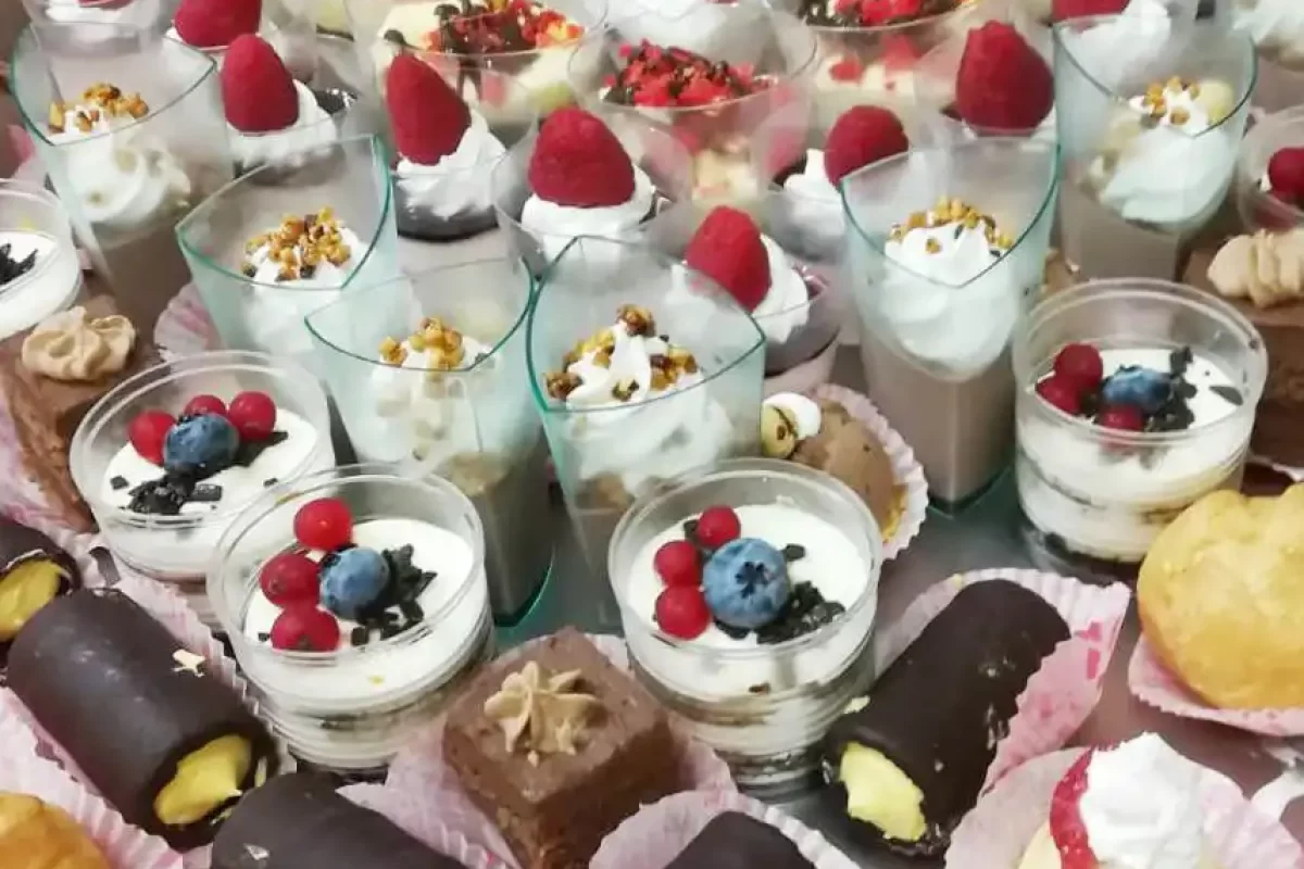 Un assortimento di dolci al cucchiaio e pasticcini decorati con frutta e crema.